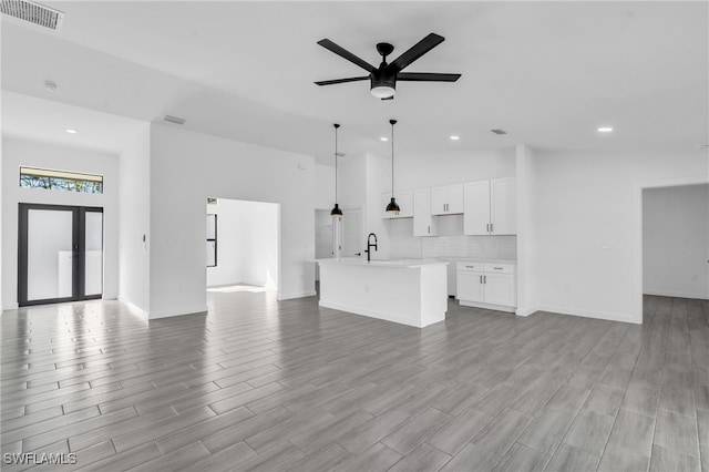 unfurnished living room featuring light hardwood / wood-style floors, high vaulted ceiling, and ceiling fan