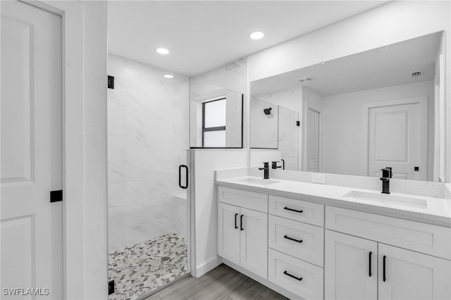 bathroom featuring walk in shower, vanity, and hardwood / wood-style flooring