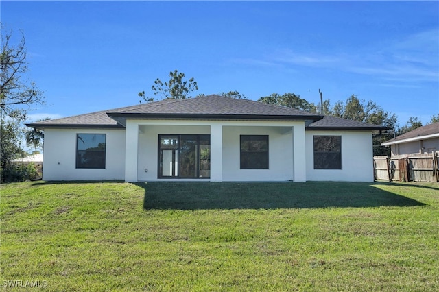 rear view of house featuring a yard