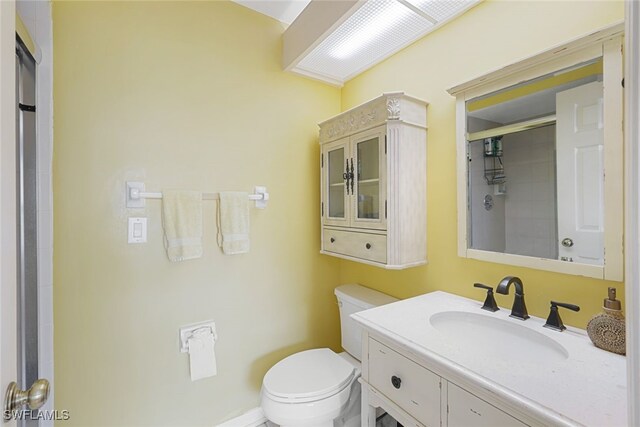 bathroom featuring walk in shower, vanity, and toilet