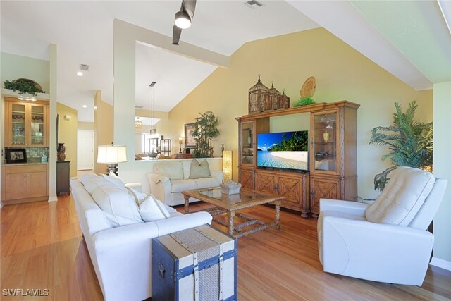 living room with ceiling fan, light hardwood / wood-style flooring, and high vaulted ceiling