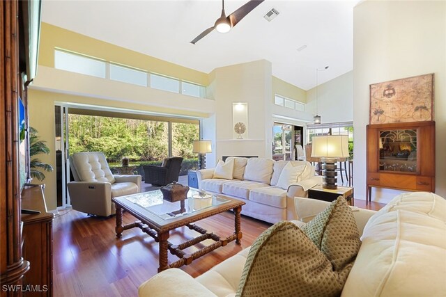 living room featuring ceiling fan, high vaulted ceiling, and dark hardwood / wood-style floors