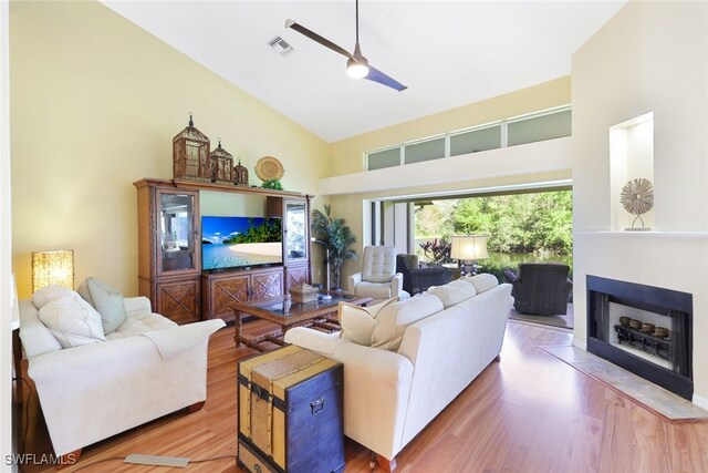 living room featuring hardwood / wood-style floors, ceiling fan, and high vaulted ceiling