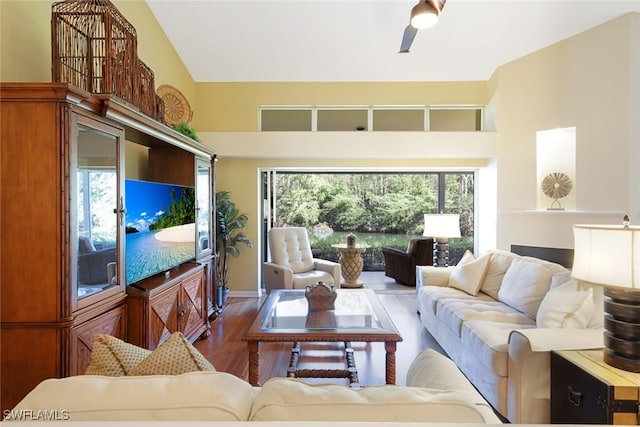 living room with hardwood / wood-style floors, high vaulted ceiling, and plenty of natural light