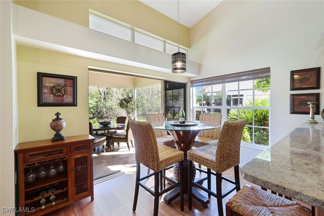 dining area featuring hardwood / wood-style flooring and a towering ceiling