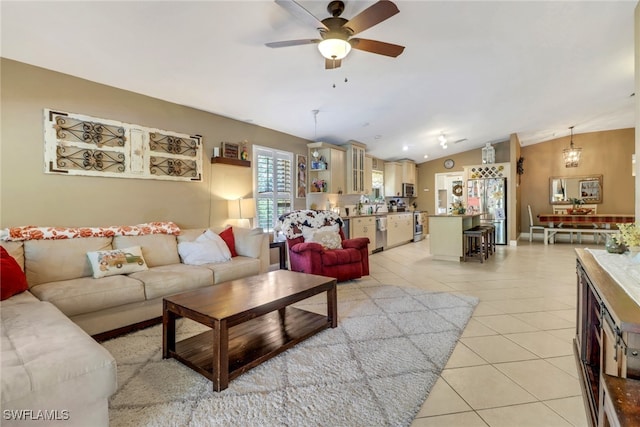 living room featuring lofted ceiling, light tile patterned floors, and ceiling fan