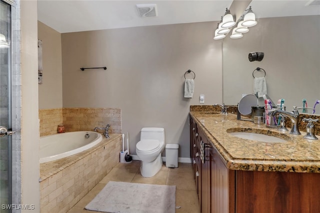 bathroom featuring tile patterned flooring, tiled tub, vanity, and toilet