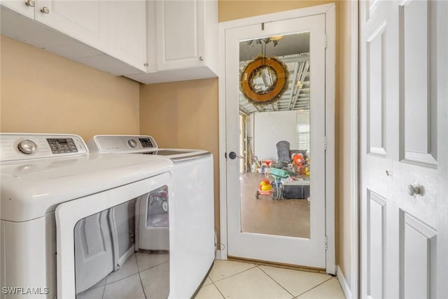 washroom featuring cabinets, light tile patterned floors, and washing machine and clothes dryer