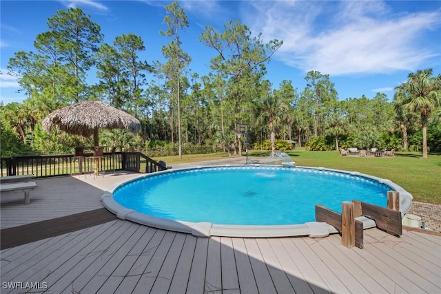 view of swimming pool featuring a wooden deck, a yard, and a gazebo