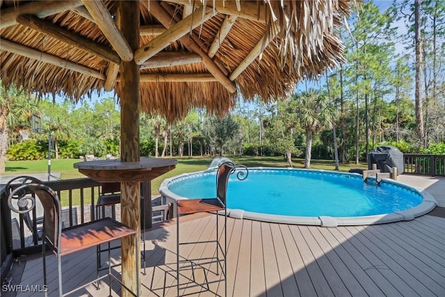 view of pool with a gazebo, a lawn, and a deck