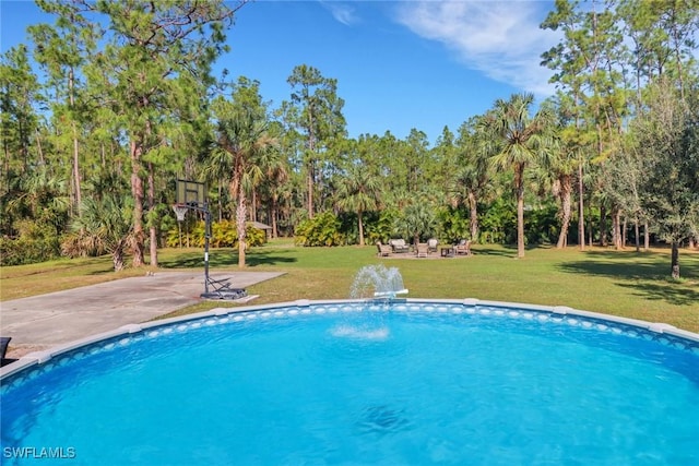 view of pool with a yard