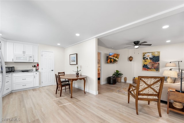 kitchen with white cabinets, ceiling fan, and light hardwood / wood-style flooring