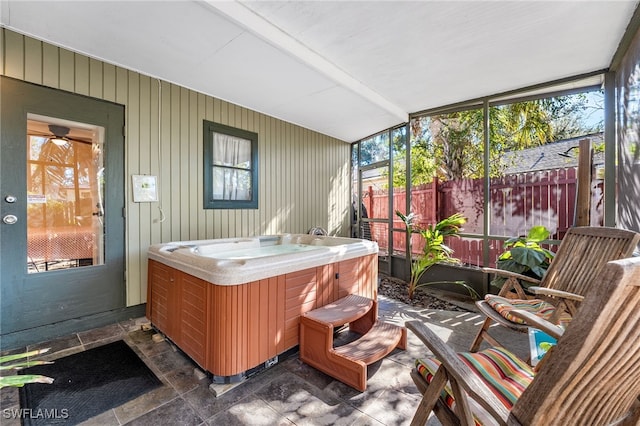 sunroom featuring a jacuzzi and beam ceiling