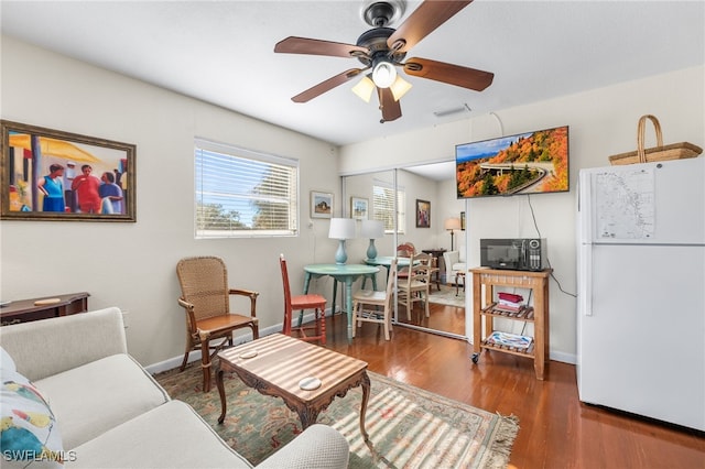 living room featuring dark hardwood / wood-style floors and ceiling fan