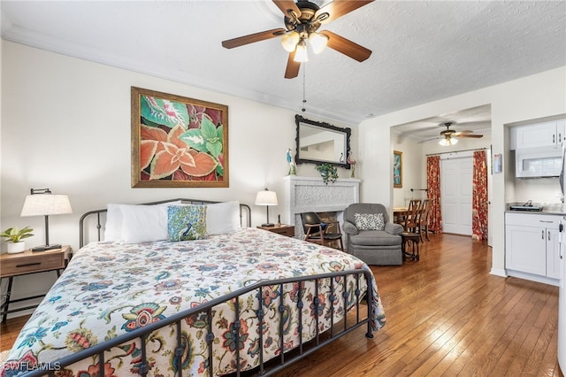 bedroom featuring a textured ceiling, ceiling fan, and dark hardwood / wood-style floors