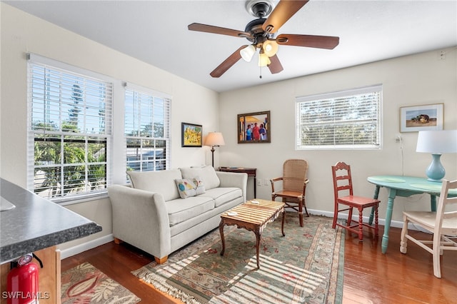 living room with dark hardwood / wood-style floors, ceiling fan, and a healthy amount of sunlight