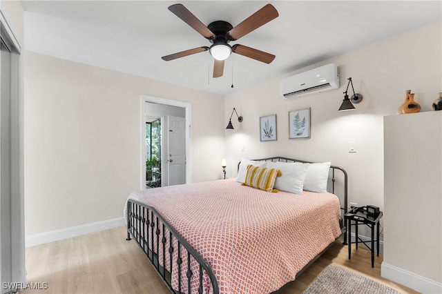 bedroom featuring ceiling fan, hardwood / wood-style floors, and a wall mounted air conditioner