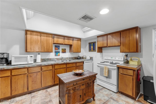 kitchen featuring sink, light tile patterned floors, and white appliances