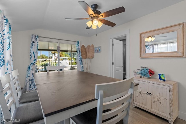 dining area with ceiling fan, lofted ceiling, and light hardwood / wood-style floors