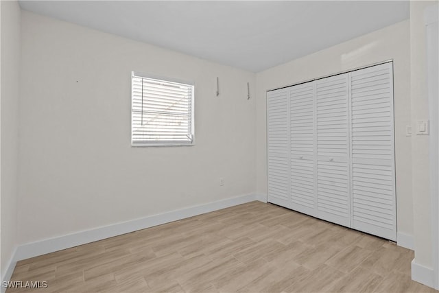 unfurnished bedroom featuring a closet and light hardwood / wood-style flooring