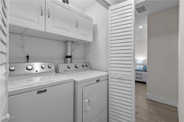 laundry room with washing machine and dryer and cabinets