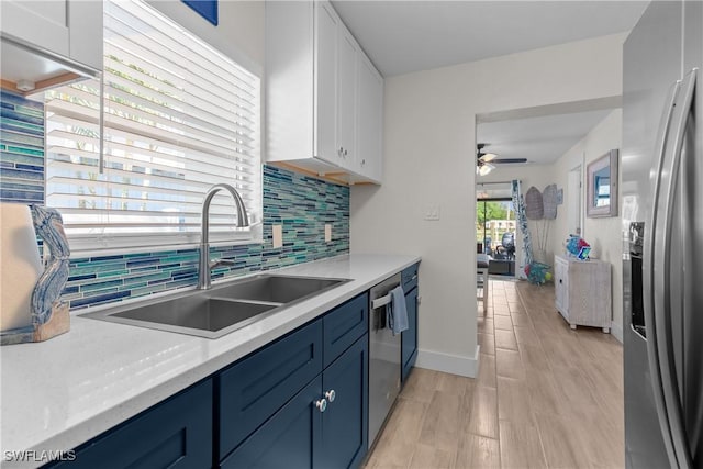 kitchen with ceiling fan, white cabinets, appliances with stainless steel finishes, and sink