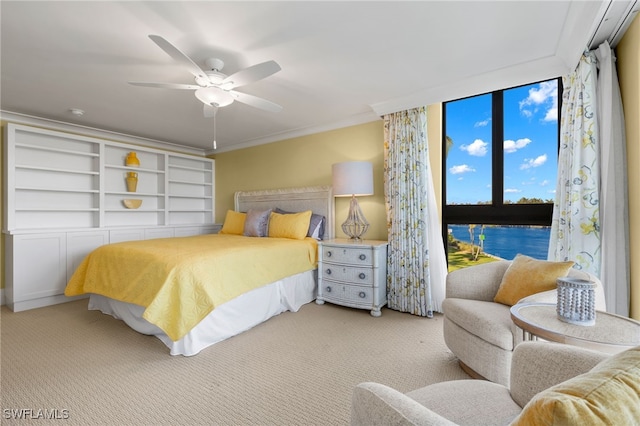 carpeted bedroom featuring ceiling fan, a water view, and crown molding