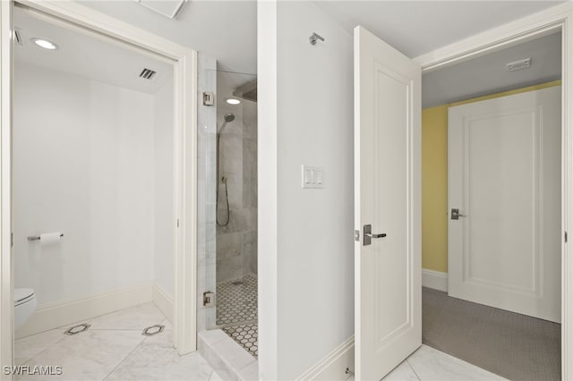 bathroom with toilet and a shower with door