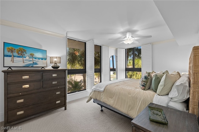 carpeted bedroom featuring ceiling fan and ornamental molding