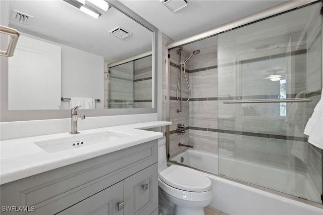 full bathroom featuring vanity, toilet, and shower / bath combination with glass door