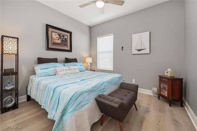 bedroom with light wood finished floors, a ceiling fan, and baseboards