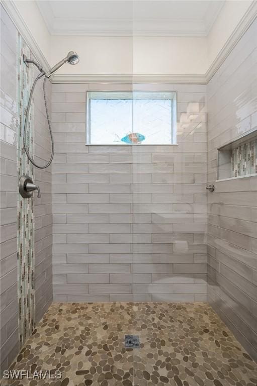 bathroom featuring ornamental molding, a tile shower, and a wealth of natural light