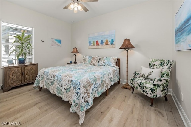 bedroom featuring light wood-style floors, baseboards, and a ceiling fan