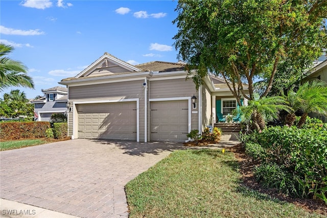 view of front of property featuring decorative driveway and an attached garage