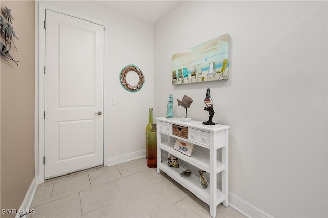 interior space featuring light tile patterned floors and baseboards