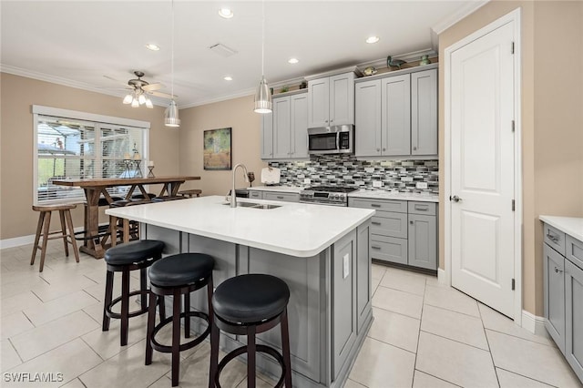 17773 Vaca Ct, Fort Myers, FL 33908 - kitchen featuring appliances with stainless steel finishes, gray cabinets, a sink, ornamental molding, and tasteful backsplash