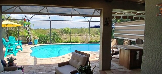 outdoor pool with glass enclosure and a patio