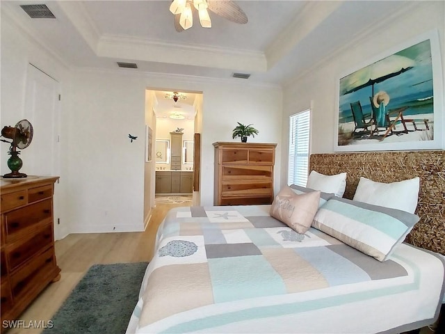 17773 Vaca Ct, Fort Myers, FL 33908 - bedroom featuring wood finished floors, ornamental molding, a tray ceiling, ensuite bath, and ceiling fan