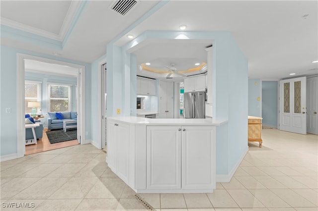 kitchen featuring white cabinets, stainless steel fridge, crown molding, and light tile patterned flooring