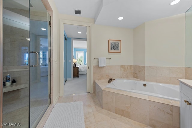 bathroom with vanity and shower with separate bathtub