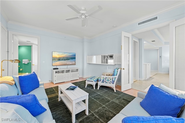 living room with tile patterned flooring, ceiling fan, and ornamental molding