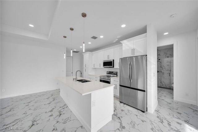 kitchen with pendant lighting, a kitchen island with sink, white cabinets, sink, and stainless steel appliances