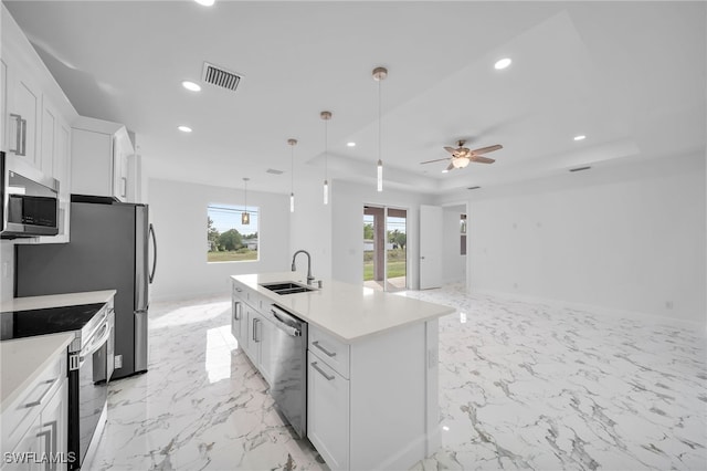 kitchen with a center island with sink, decorative light fixtures, white cabinetry, and appliances with stainless steel finishes