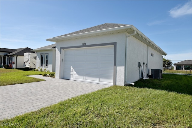 view of side of home featuring a lawn, central AC, and a garage