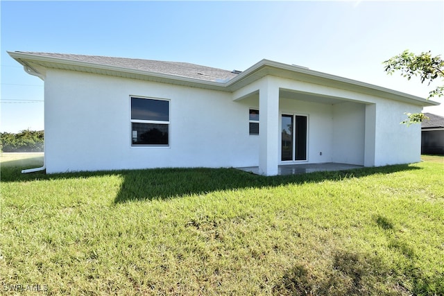 rear view of property with a lawn