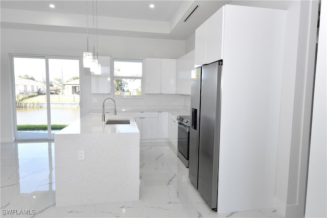 kitchen with appliances with stainless steel finishes, sink, decorative light fixtures, a water view, and white cabinets