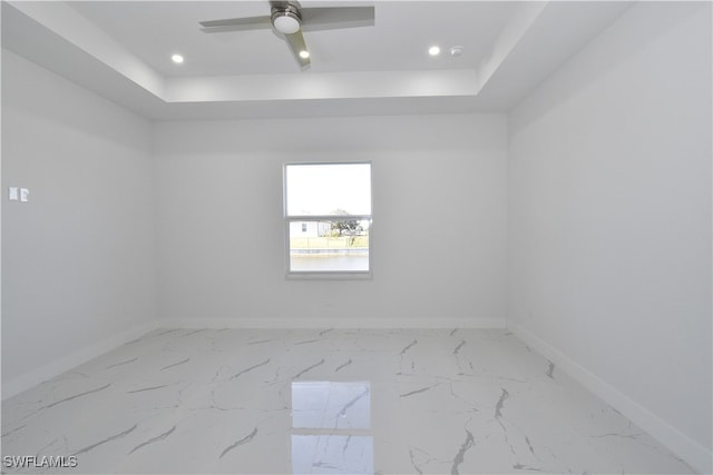 unfurnished room featuring ceiling fan and a tray ceiling