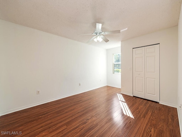 unfurnished bedroom featuring dark hardwood / wood-style floors, ceiling fan, a textured ceiling, and a closet