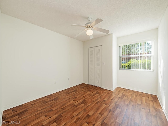 unfurnished bedroom featuring ceiling fan, a closet, a textured ceiling, and hardwood / wood-style flooring