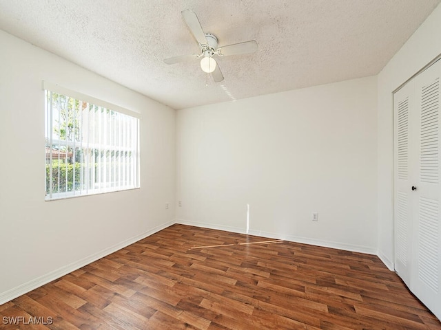 unfurnished bedroom featuring a textured ceiling, dark hardwood / wood-style flooring, a closet, and ceiling fan